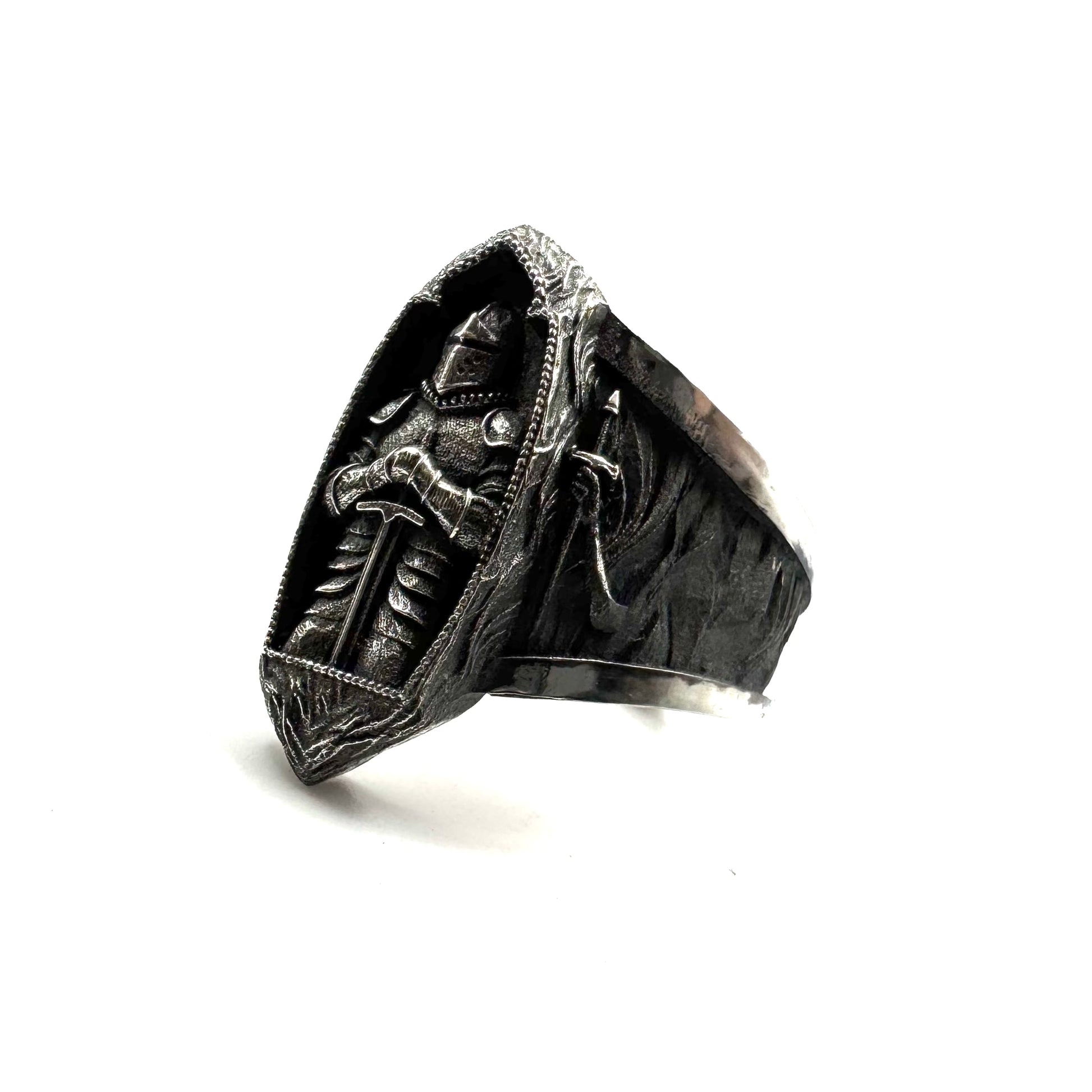 Silver ring with intricate design on a white background