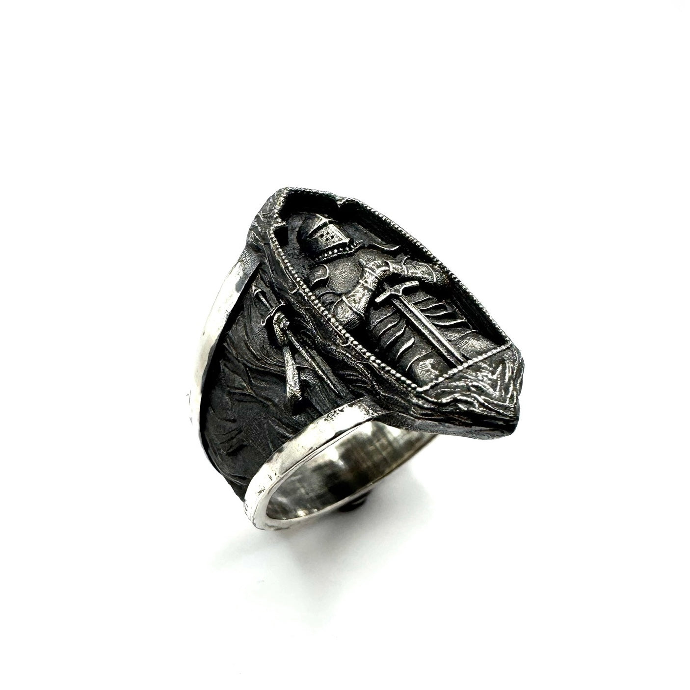 Silver ring with detailed design on a white background