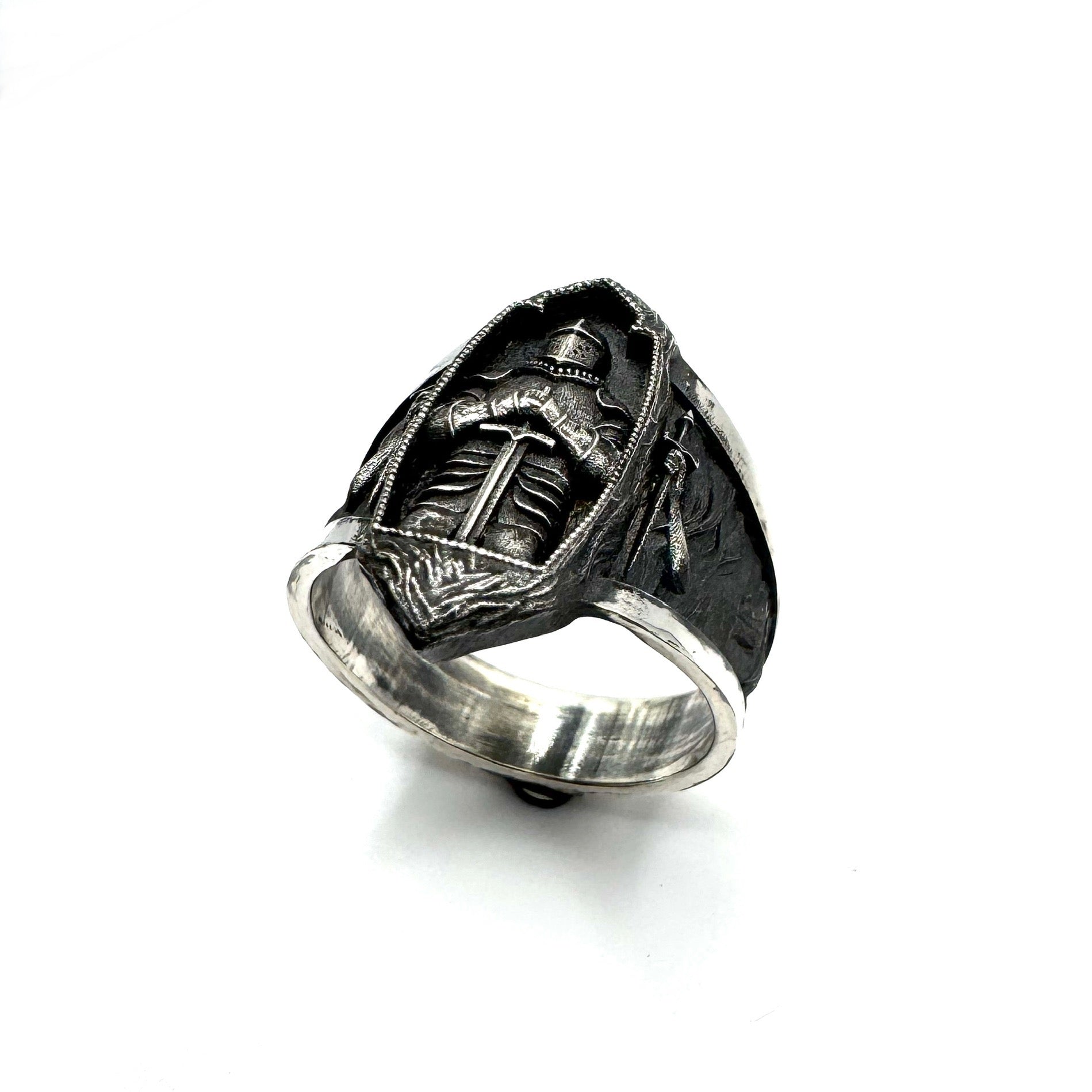 Silver ring with detailed design on a white background