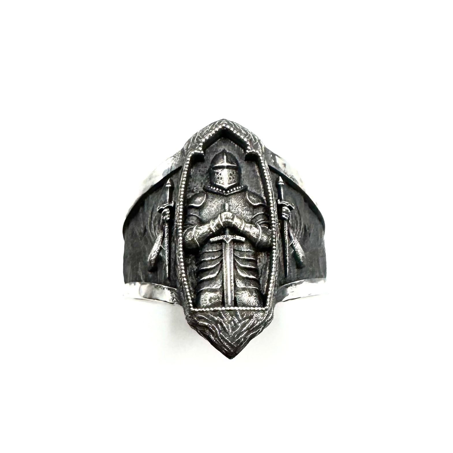 Silver ring with a detailed design on a white background
