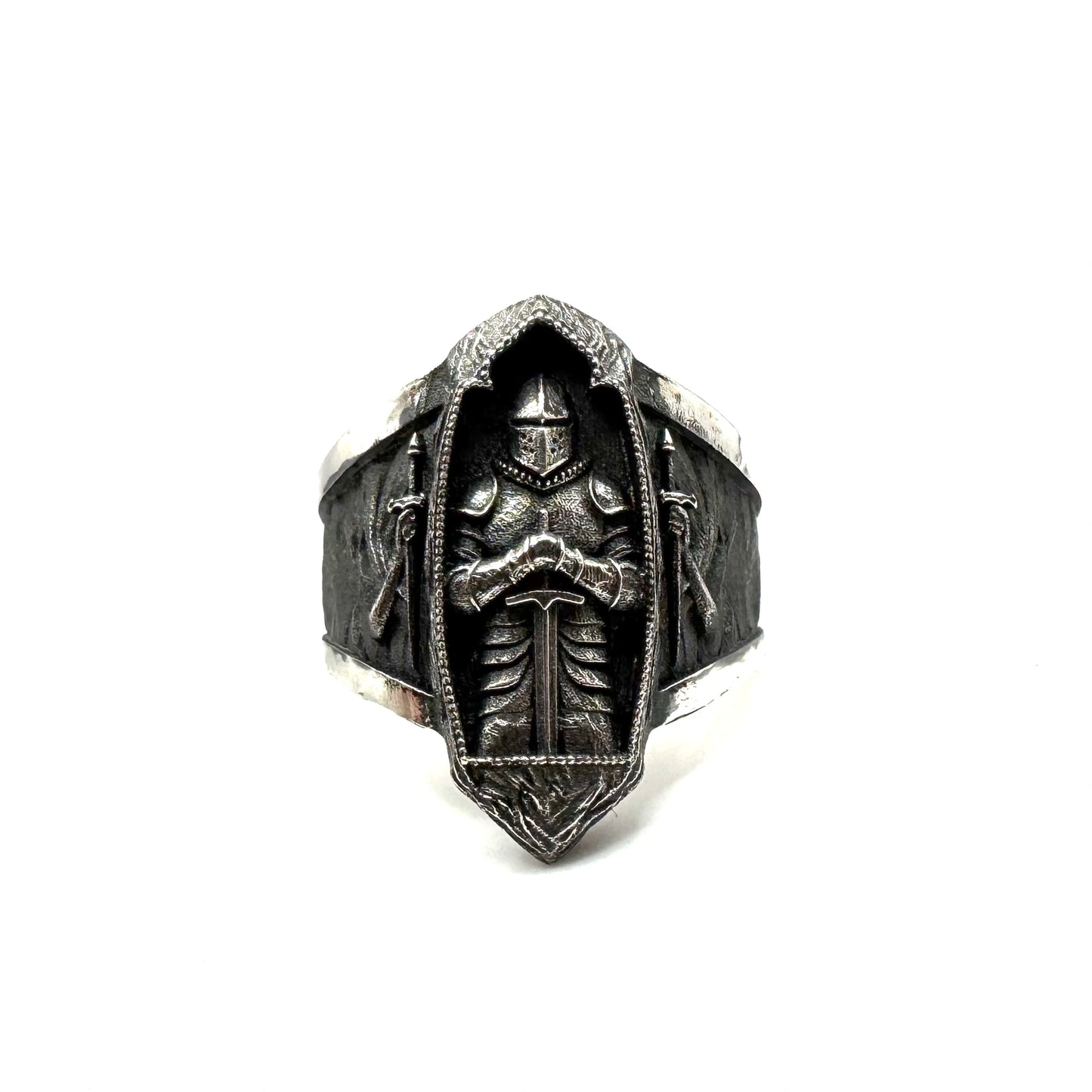 Silver ring with intricate design on a white background