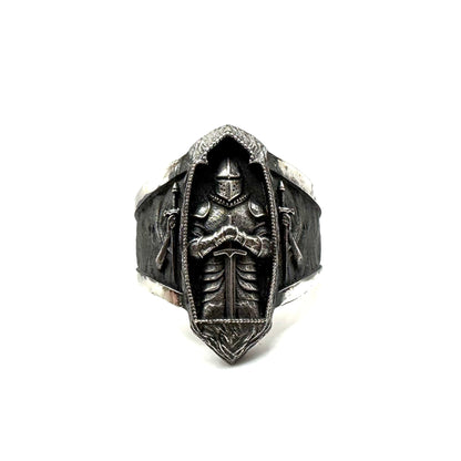 Silver ring with intricate design on a white background